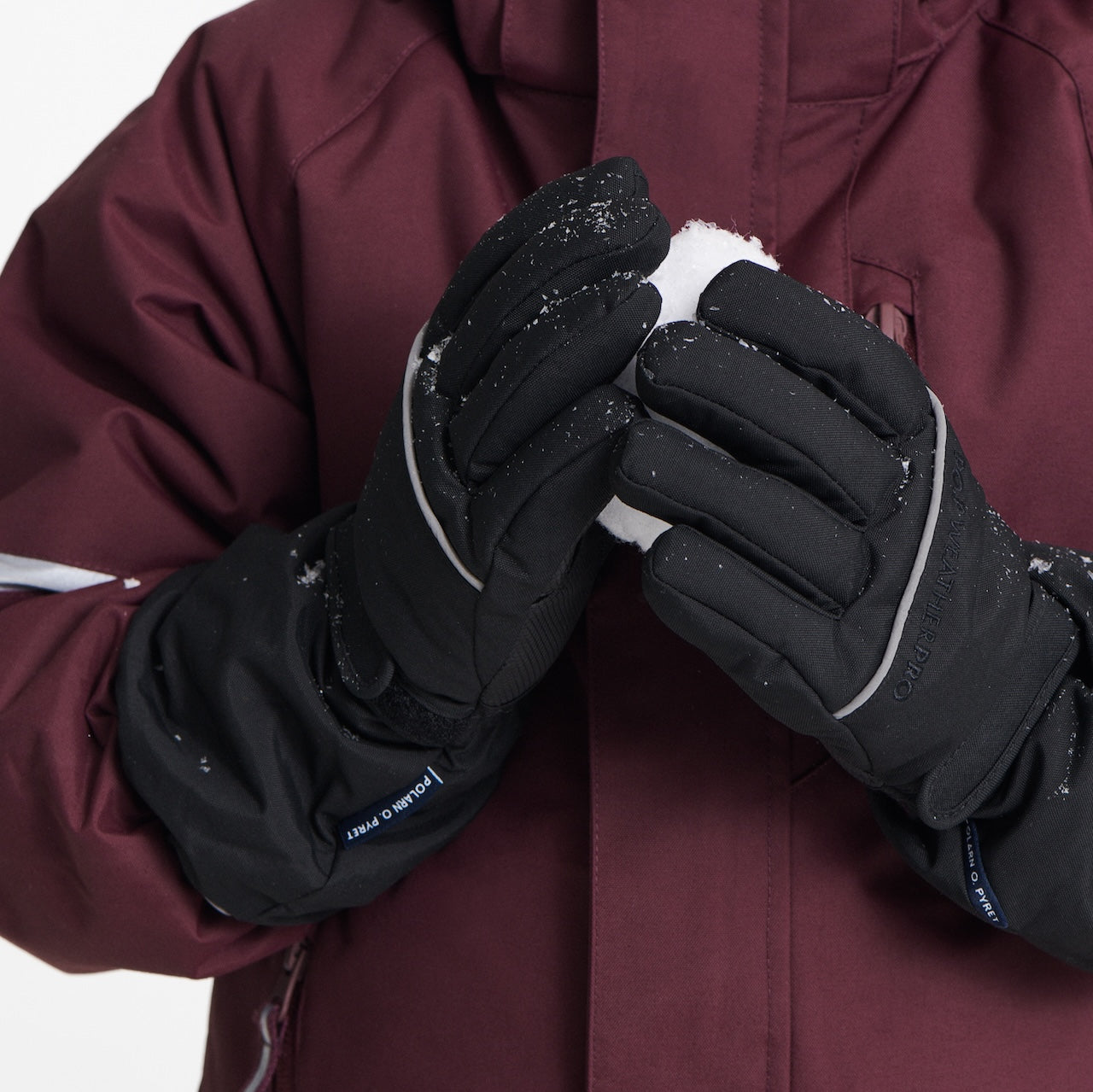 Kids playing in the snow wearing warm winter jackets and mittens