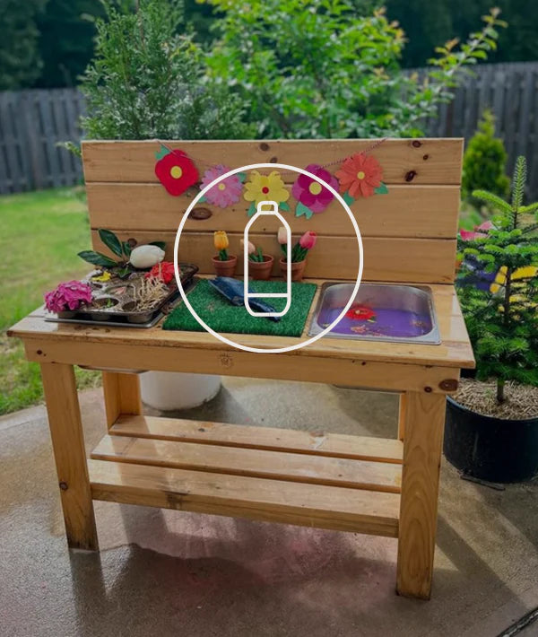 Children’s outdoor mud kitchen decorated with colorful paper flowers