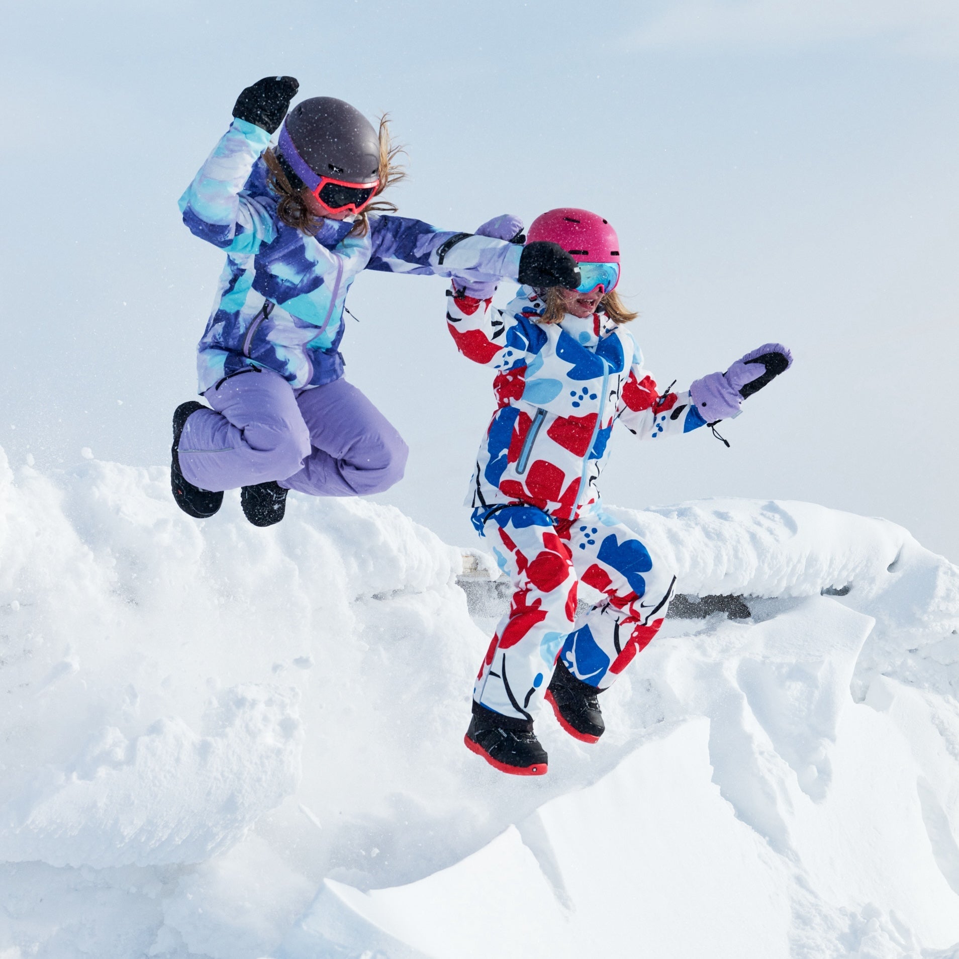 Outdoor winter fun for kids wearing warm waterproof clothing and gloves at a forest campsite
