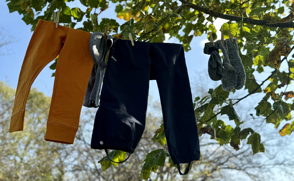 Clothing items hanging on a clothesline with trees in the background