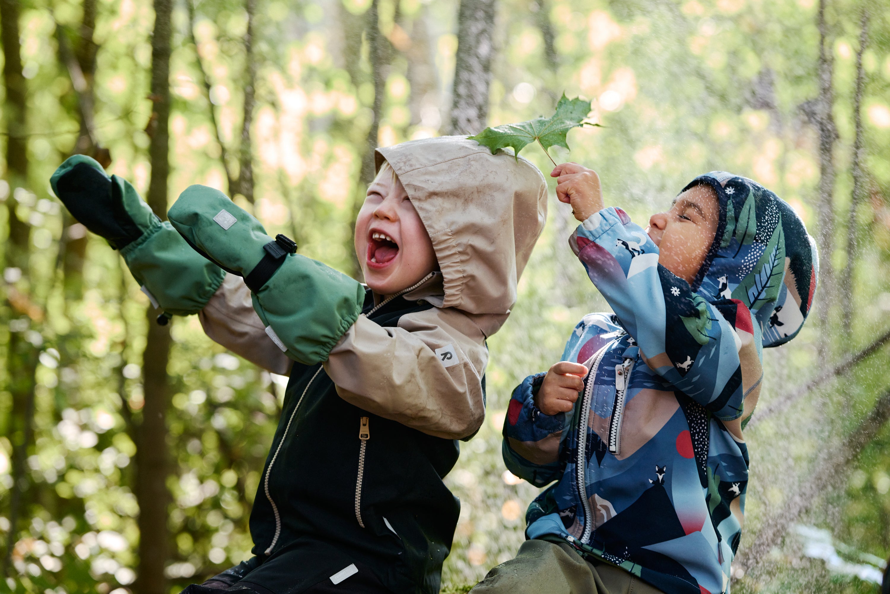 Two children playing in a forest with trees in the background