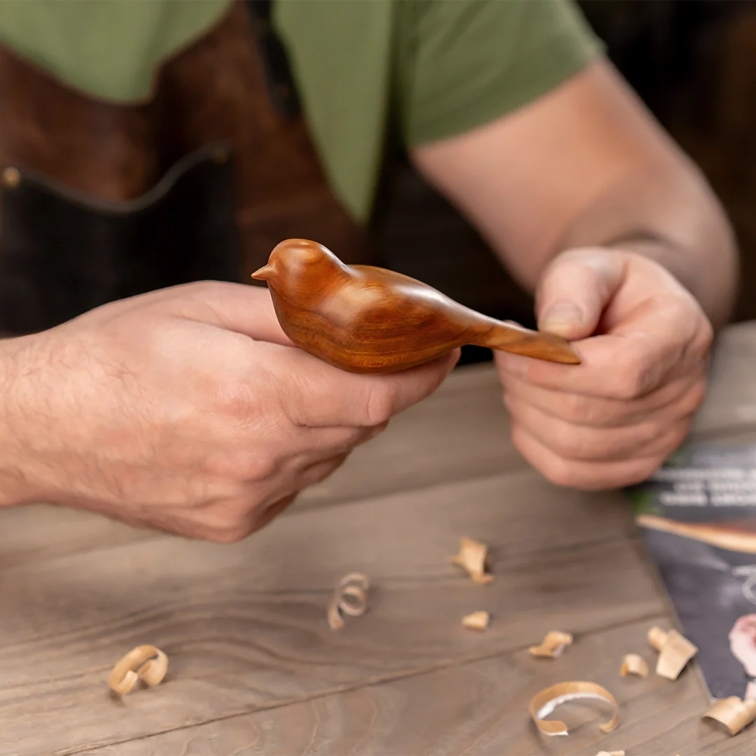 Person holding finished wooden bird from
carving kit