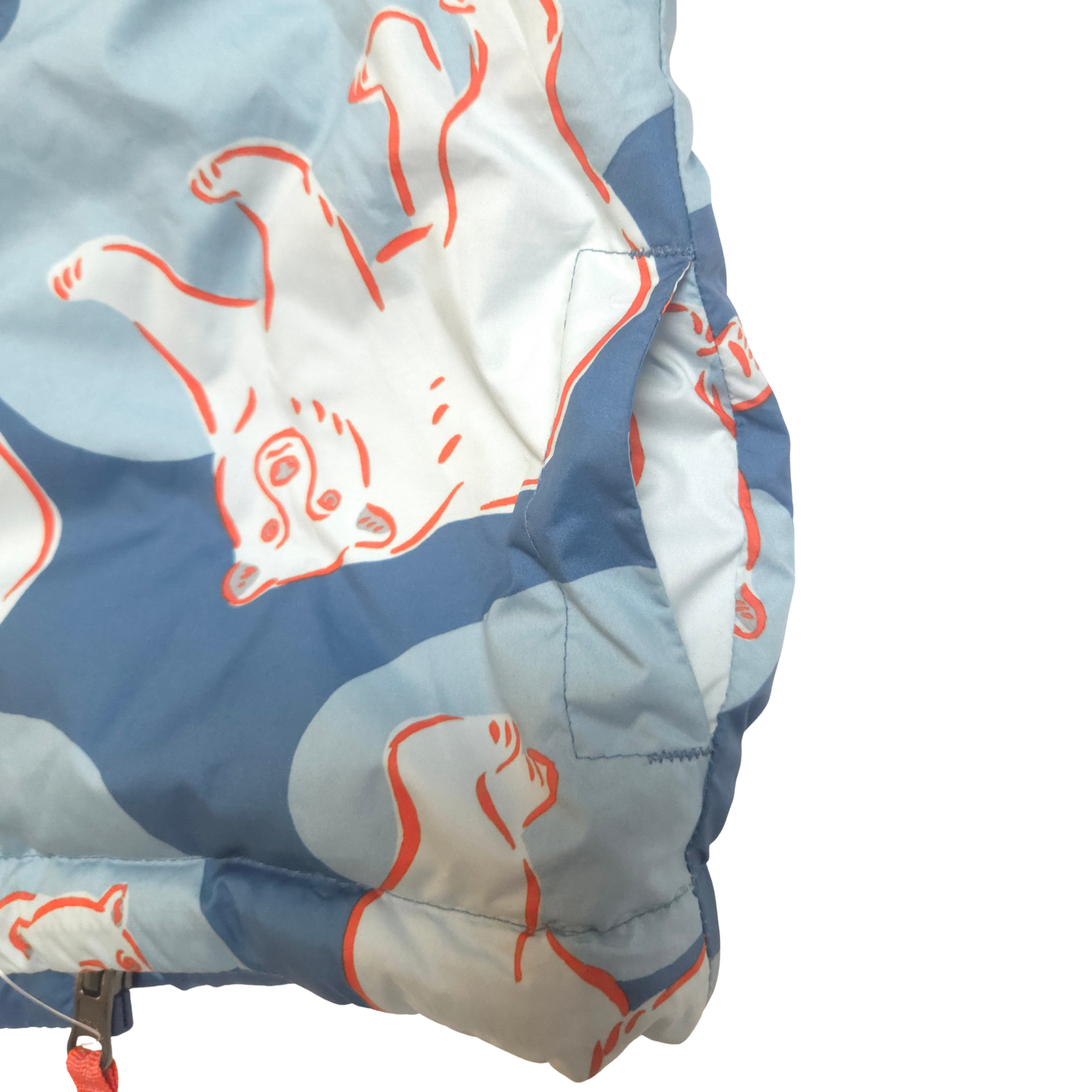 Close-up of a quilt with blue, white, and orange patterns on a white background