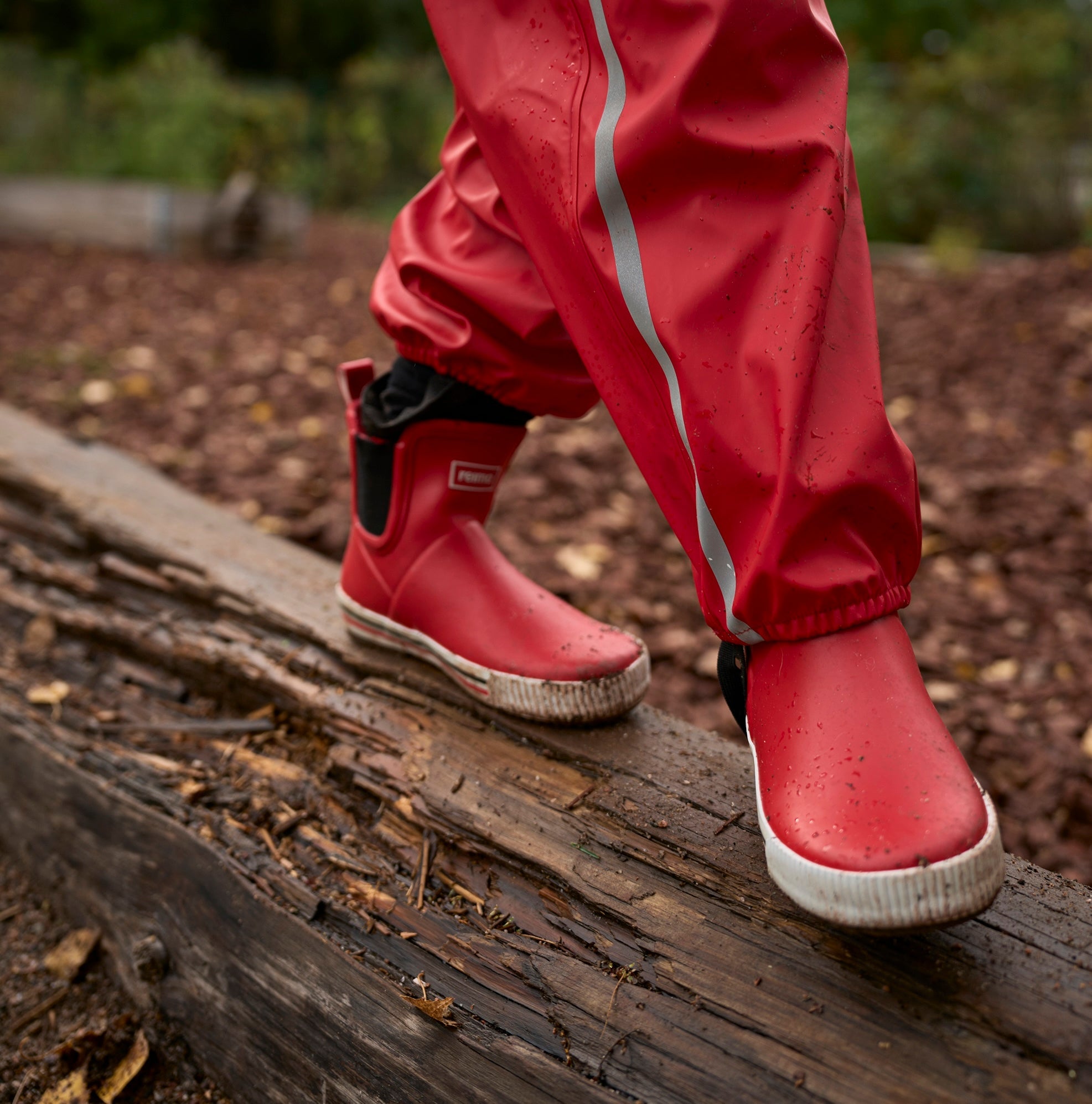 Waterproof rain gear for kids — playful moment by the lakeshore on a warm afternoo
