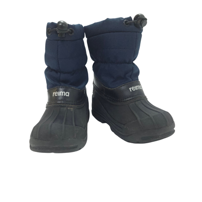 Pair of navy winter boots with black soles on a white background