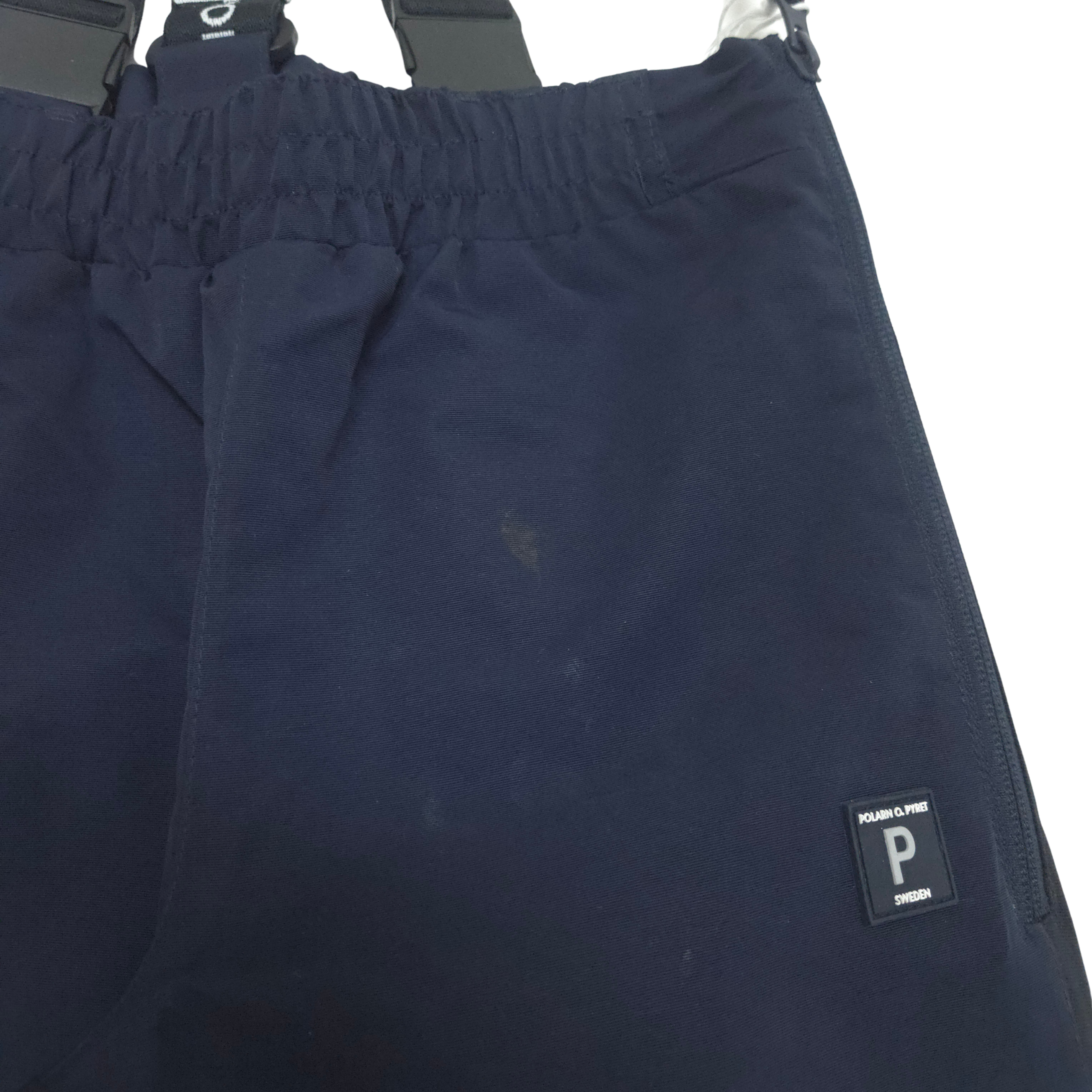 Navy blue pants with a brand logo on a white background stain detail 